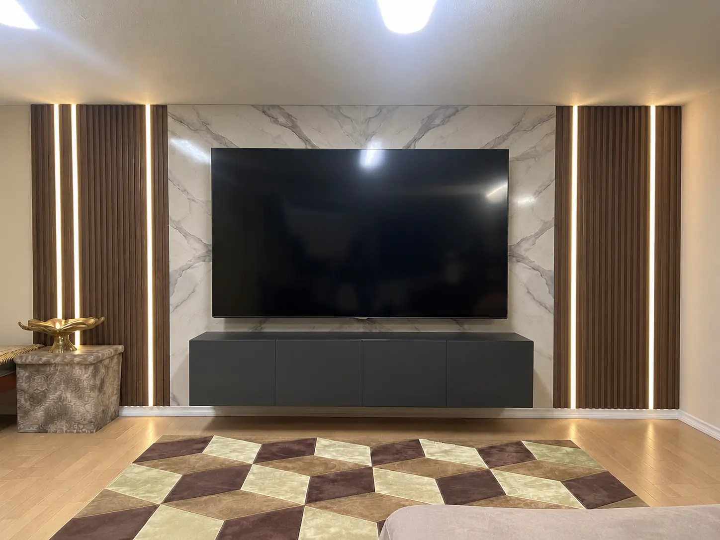 Custom walnut fluted and marble media wall with LED lighting in Winnipeg