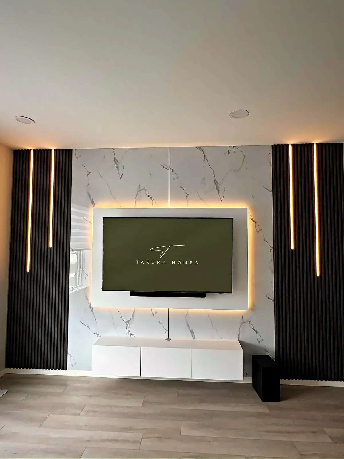 White marble and black fluted panel TV feature wall installed by Takura Homes in Winnipeg